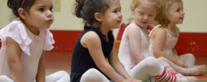 Young dancers sit and stretch