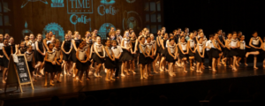 Large group of dancers wearing black and white on stage
