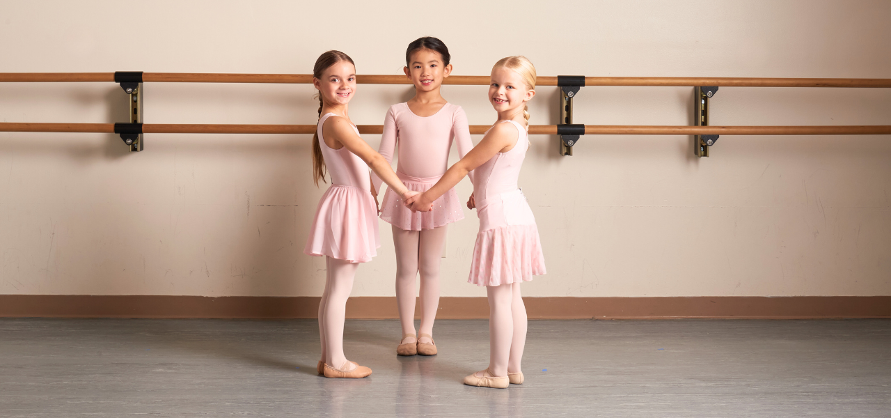 Dancers hold hands in a circle during a creative movement class